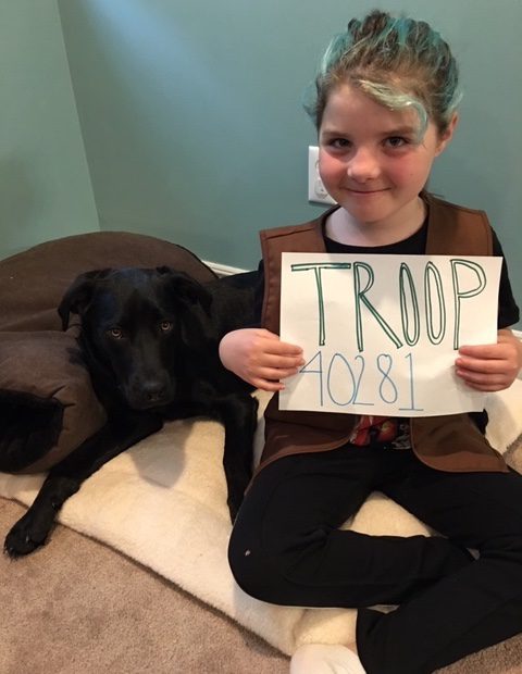 girl scouts visit ER, girl holds sign with troop number