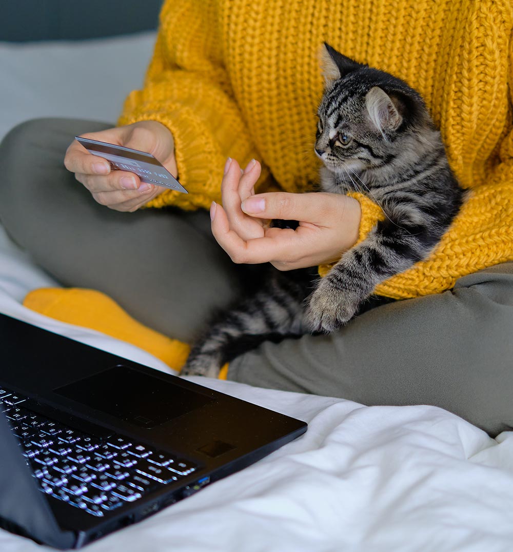 woman paying for veterinary care while holding a cat